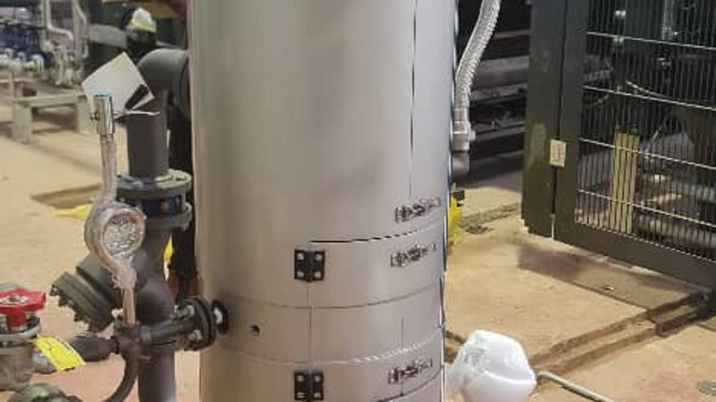 Vertical industrial pipeline strainer used for filtering debris from fluid pipelines in a mechanical processing plant.